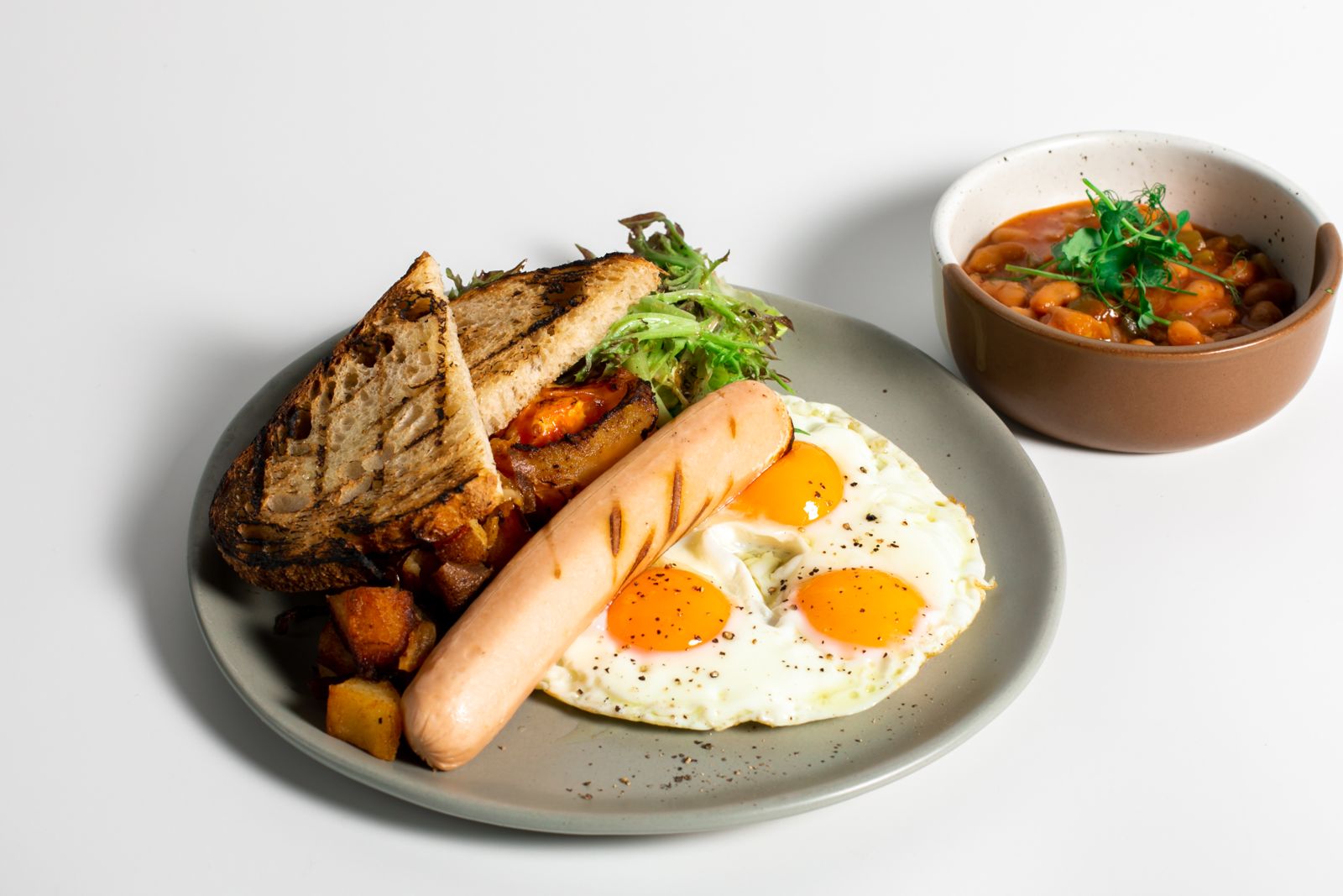 Cliche Eggs with triple sunny side ups, sourdough and sausage