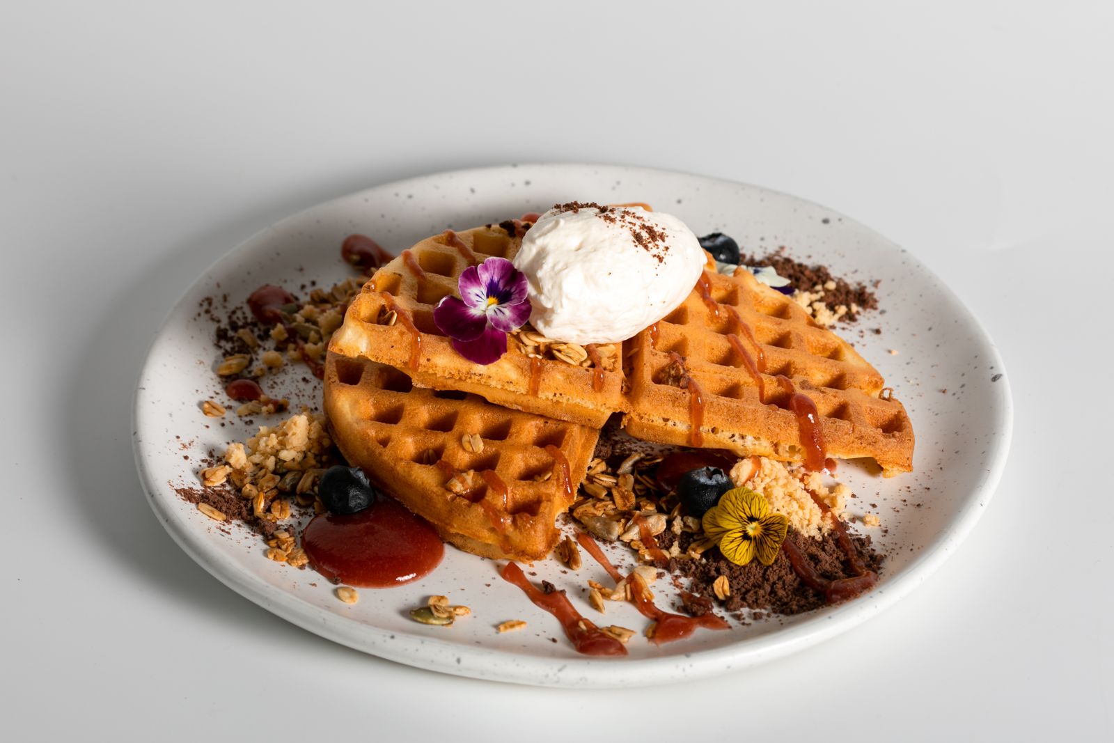 Some egg Waffle with chantilly cream, granola and berries