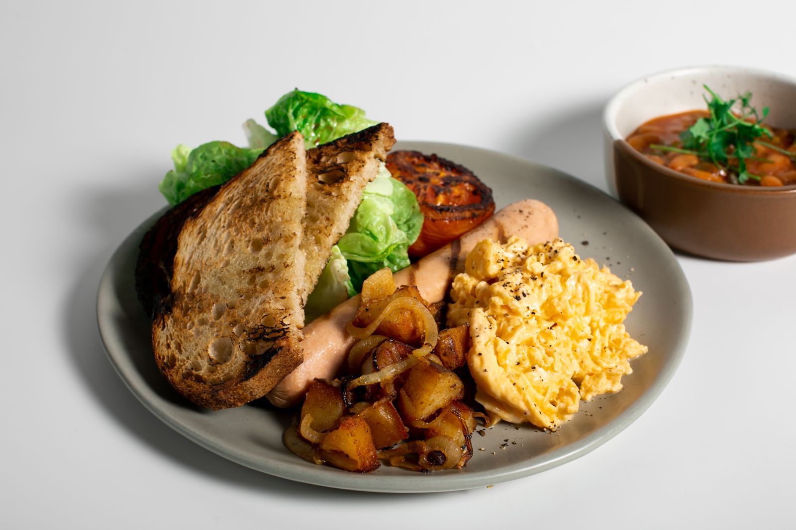 Cliche Eggs with creamy scrambled eggs, sourdough and sausages